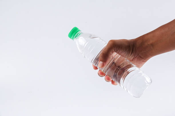 istock Cropped Hand Holding Water Bottle Against White Background 1132556685