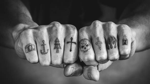 Close up of tattoos on fingers and knuckles stock photo
