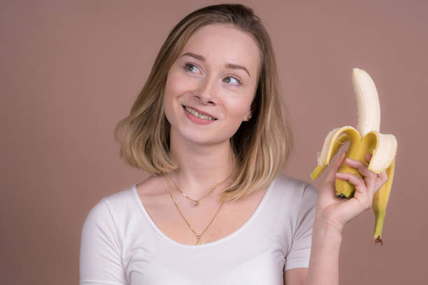 istock cute girl have fun with a banana 1132559817