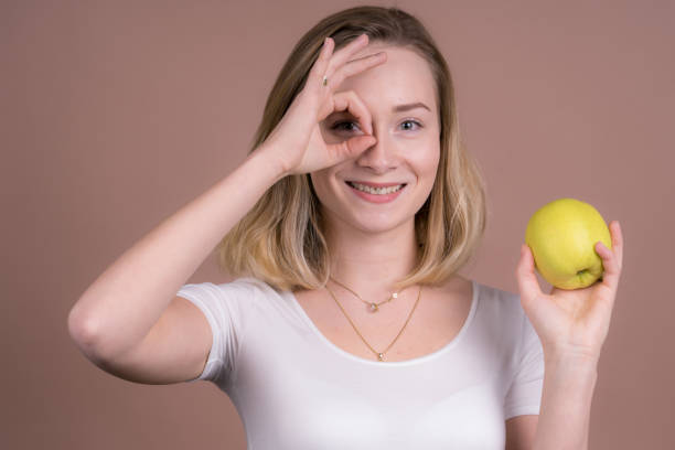 istock cute girl eats a apple and have fun with a frute 1132559896