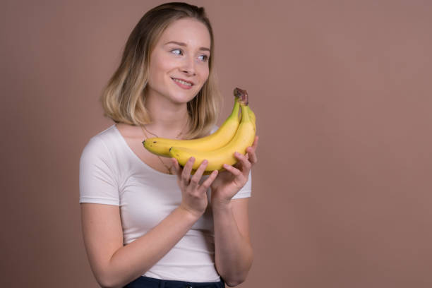 istock cute girl have fun with a banana 1132559963