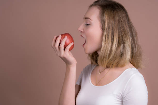 istock cute girl eats a apple and have fun with a frute 1132560032