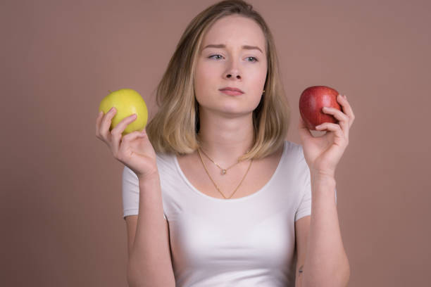 istock cute girl eats a apple and have fun with a frute 1132560162