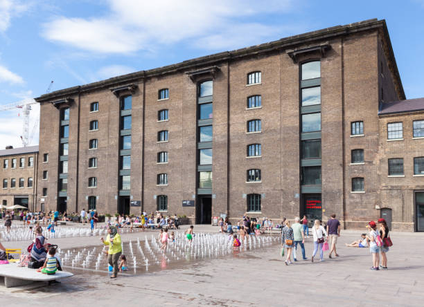 Granary Square, King's Cross, London. People playing in the water fountain outside the redeveloped Granary Building in King's Cross. granary stock pictures, royalty-free photos & images