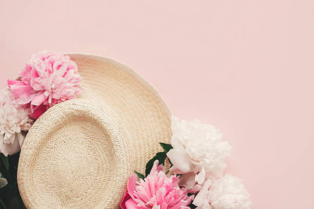istock Stylish  straw rustic hat with pink and white peonies on pink paper flat lay with space for text. Hello summer. International womens day. Happy mothers day. Greeting card mockup. 1132563800