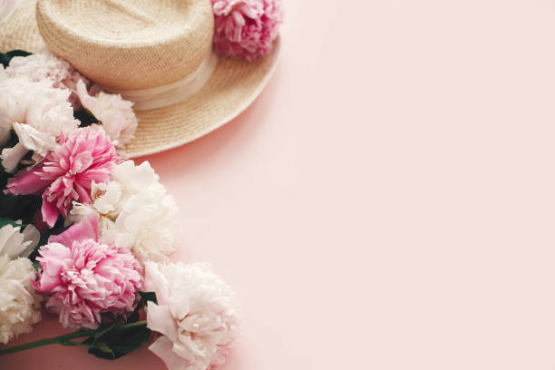 istock Stylish  straw rustic hat with pink and white peonies on pink paper with space for text. Hello summer. International womens day. Happy mothers day. Greeting card mockup. 1132564092