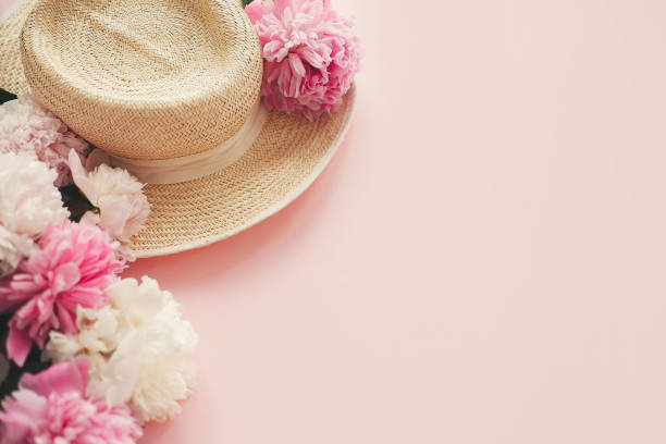 istock Stylish  straw rustic hat with pink and white peonies on pink paper with space for text. Hello summer. International womens day. Happy mothers day. Greeting card mockup. 1132565136