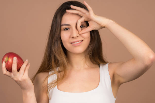 istock cute girl eats a apple and have fun with frute food 1132565733