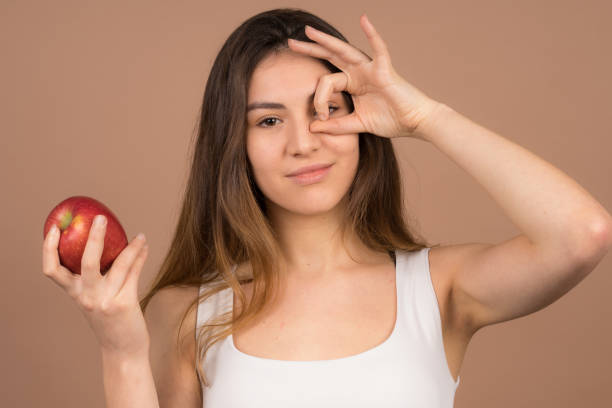 istock cute girl eats a apple and have fun with frute food 1132565741
