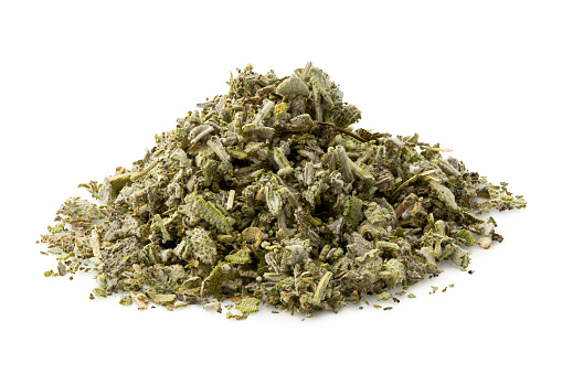 A pile of dried rubbed sage isolated on white.