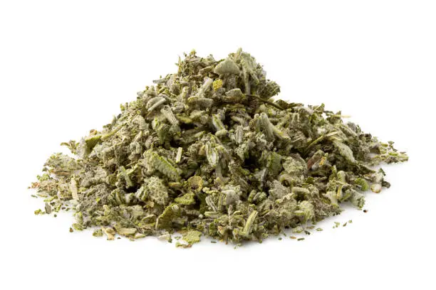 Photo of A pile of dried rubbed sage isolated on white.