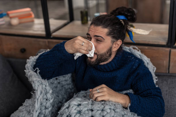 istock Unhappy young man suffering from running nose 1132569694