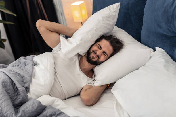 istock Unhappy cheerless young man covering his ears 1132569748