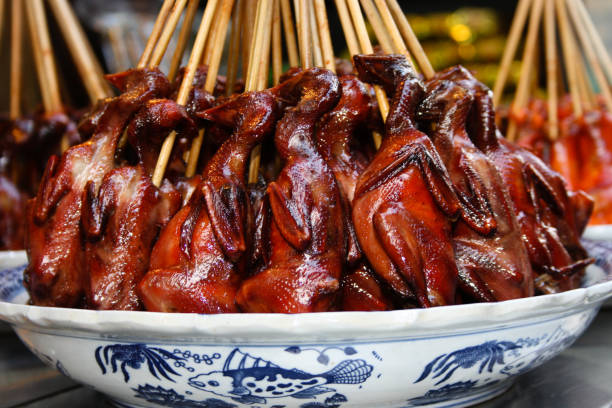 Red and shiny grilled birds on sticks, Shanghai cuisine, Qibao, China Red and shiny grilled birds on sticks, Shanghai cuisine, Qibao, China squab pigeon meat stock pictures, royalty-free photos & images