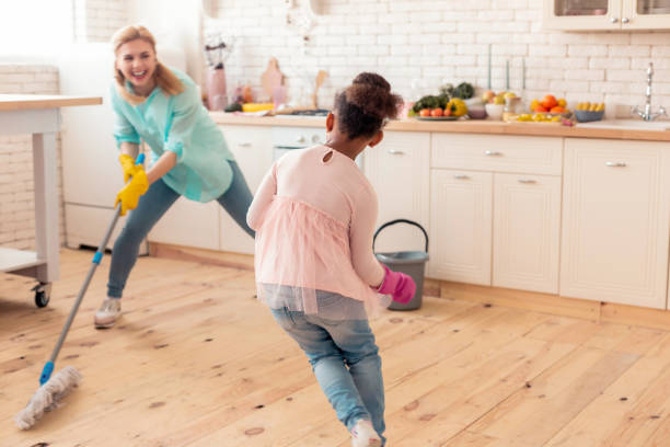 istock Mother and daughter playing hide and seek while cleaning the kitchen 1132579512