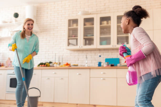 istock Cute curly daughter having much fun helping her mom with cleaning 1132579514