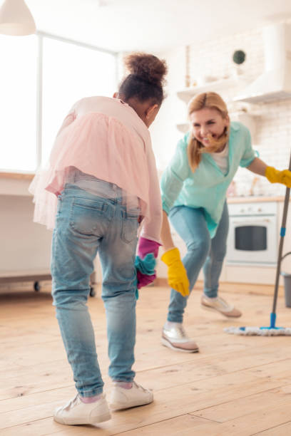 istock Mother and daughter dancing and moving while cleaning the kitchen 1132579534