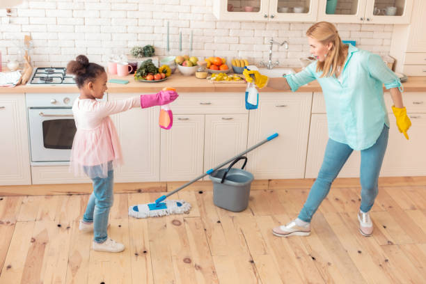 istock Mother and daughter playing and having fun while cleaning 1132579538