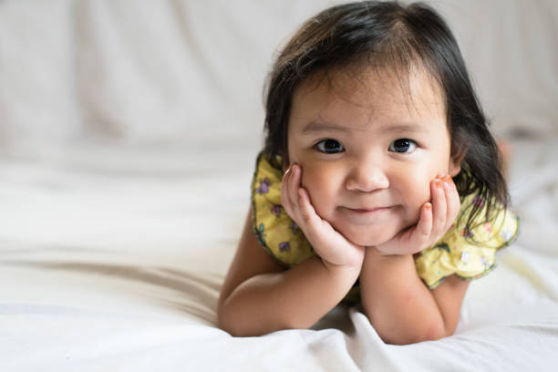 istock Portrait Of Cute Girl Smiling While Lying On Bed 1132582949