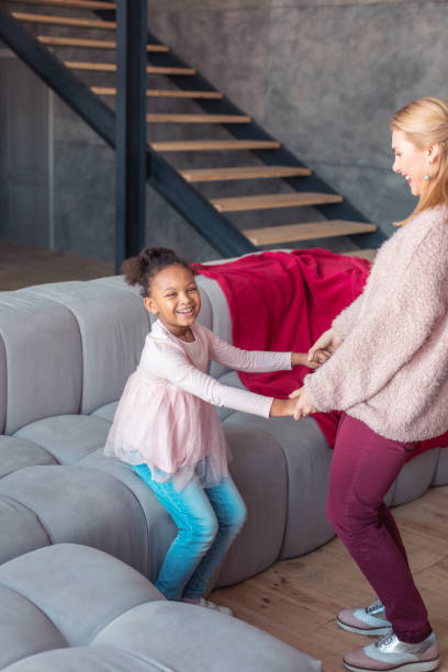 istock Beaming girl laughing while dancing with her loving mom 1132584407