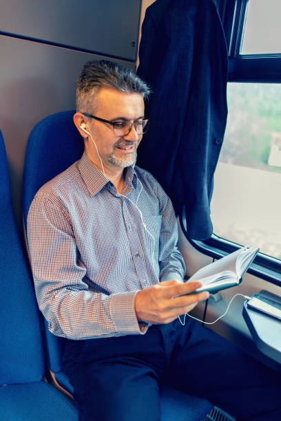 istock Businessman reading book and traveling by train 1132589600