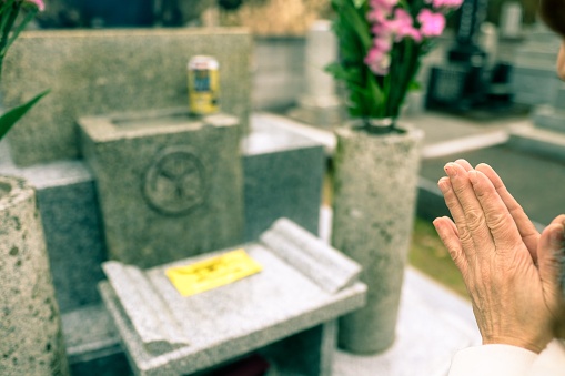 A Japanese woman is praying for ancestor's grave