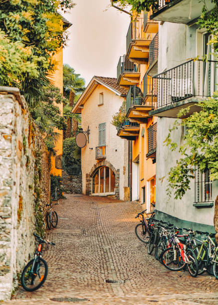 cobblestoned street avec des vélos dans un complexe de luxe romantique à ascona - ticino canton stone switzerland water photos et images de collection