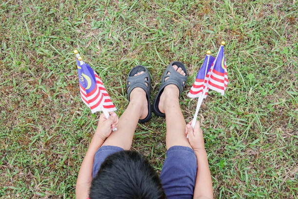 istock Boy Holding Malaysian Flags On Field 1132591258