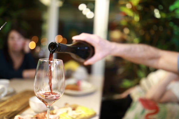 istock Person pouring red wine 1132597213