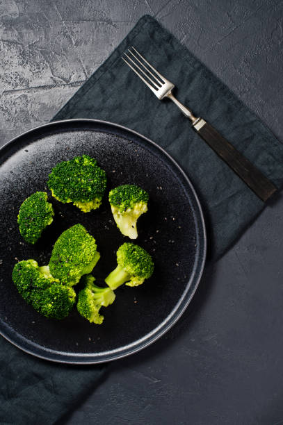 istock Broccoli on a black plate. Black background, top view. 1132598878