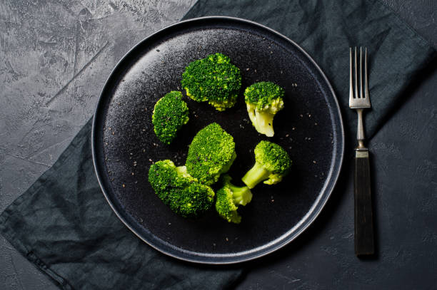 istock Boiled broccoli on a black plate. Black background, top view, 1132598925