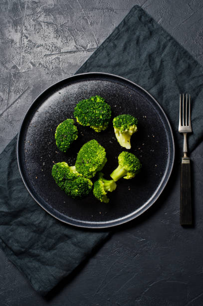istock Boiled broccoli on a black plate. Black background, top view. 1132598951