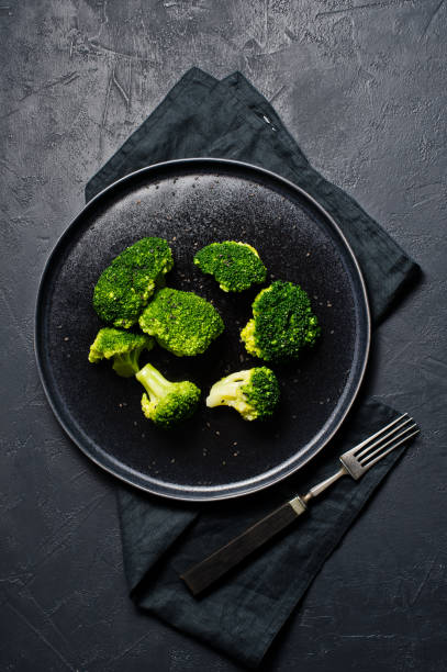 istock Broccoli on a black plate. Black background, top view. 1132599004