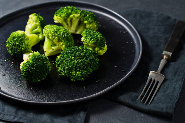 istock Raw broccoli on a black plate. Black background, side view, close-up. 1132599057