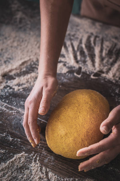 istock Woman Chef wearing apron kneading dough by hand at bakery 1132599073