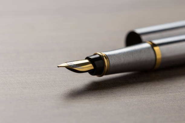 istock fountain pen on wooden table 1132599809