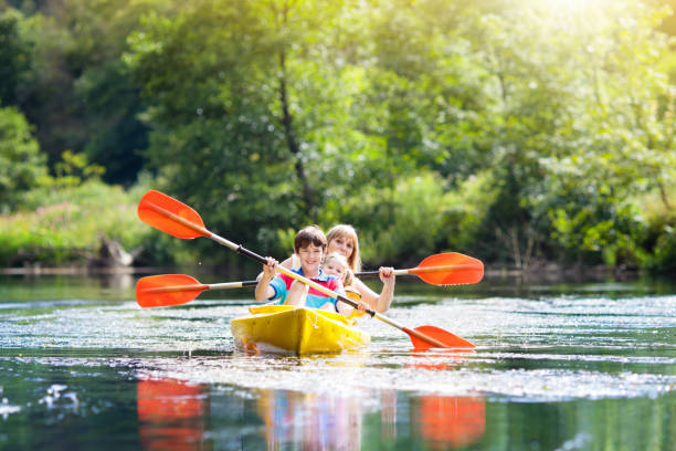 Child on kayak. Kids on canoe. Summer camping. Child with paddle on kayak. Summer camp for kids. Kayaking and canoeing with family. Children on canoe. Family on kayak ride. Wild nature and water fun on summer vacation. Camping and fishing. kayaking stock pictures, royalty-free photos & images