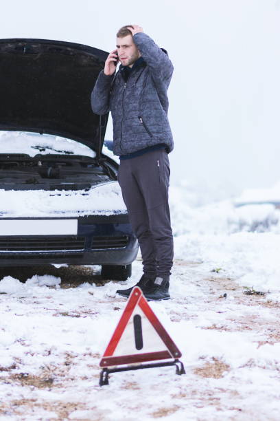 istock Young Man Talking Over Mobile Phone While Standing By Car On Snow Covered Field Against Sky 1132602254