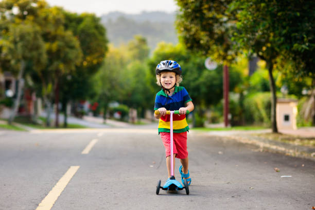 istock Child on scooter in summer. Kids skate. 1132603499