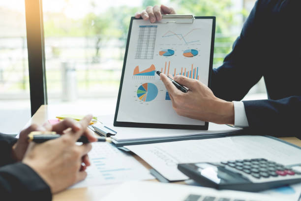 istock Midsection Of Businessmen Discussing Over Graph On Table 1132604466
