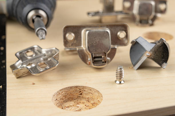 istock Milling the hole for the can hinge. Joinery works when assembling chipboard furniture. light background. 1132610545