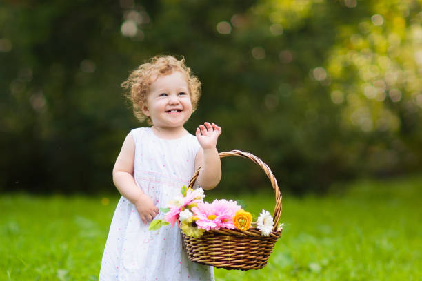 Beautiful ten months baby girl playing in a pink basket. Early stimulation for toddlers concept.