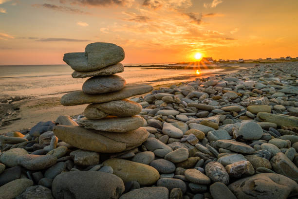 Pile of rocks kern on a beach in Penhors, Brittany, France, at sunset stock photo