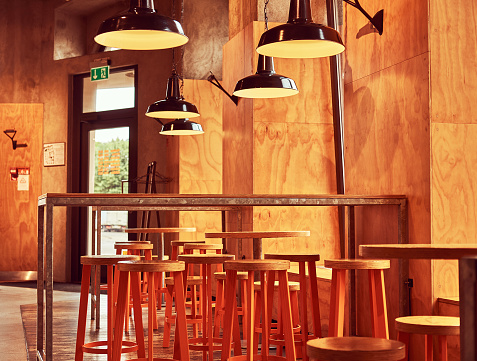 Interior of new modern restaurant or cafe with wooden wall and furniture.