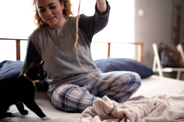 istock Young woman playing on the bed with her cat 1132617293