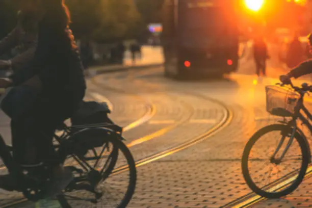 Photo of Blurred of people riding bicycle during the sunset in the city