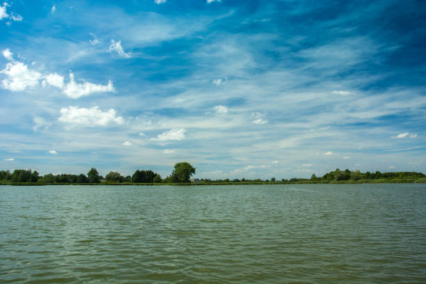 White clouds on the blue sky above the lake