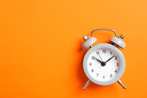 istock Retro alarm clock on color background, space for text 1132620431