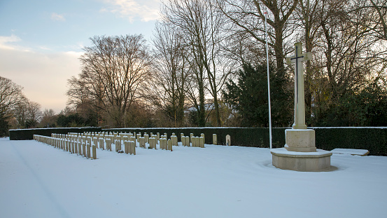 gravestones covered with snow at winter evening, municipal cemetery in Amsterdam, The Netherlands