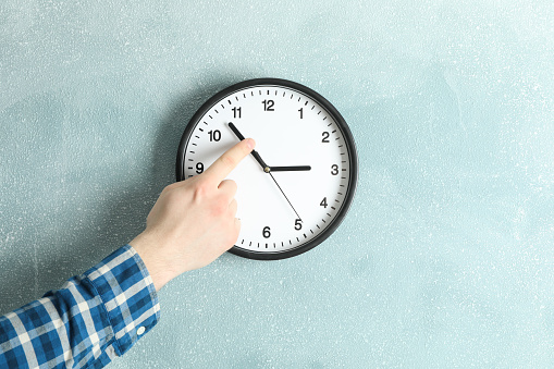 Man changing time on beautiful wall clock, space for text